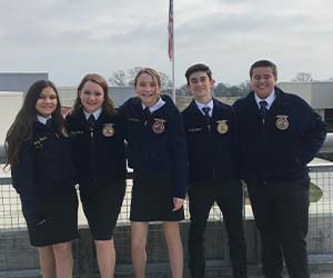 FFA students posing together in front of American Flag