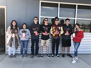 Students holding floral arrangements