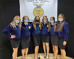 Group of girl FFA students in front of team banner