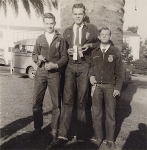 black and white photo of three FFA members holding ribbons