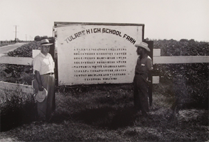 black and white photo of two men and Tulare High School farm sign